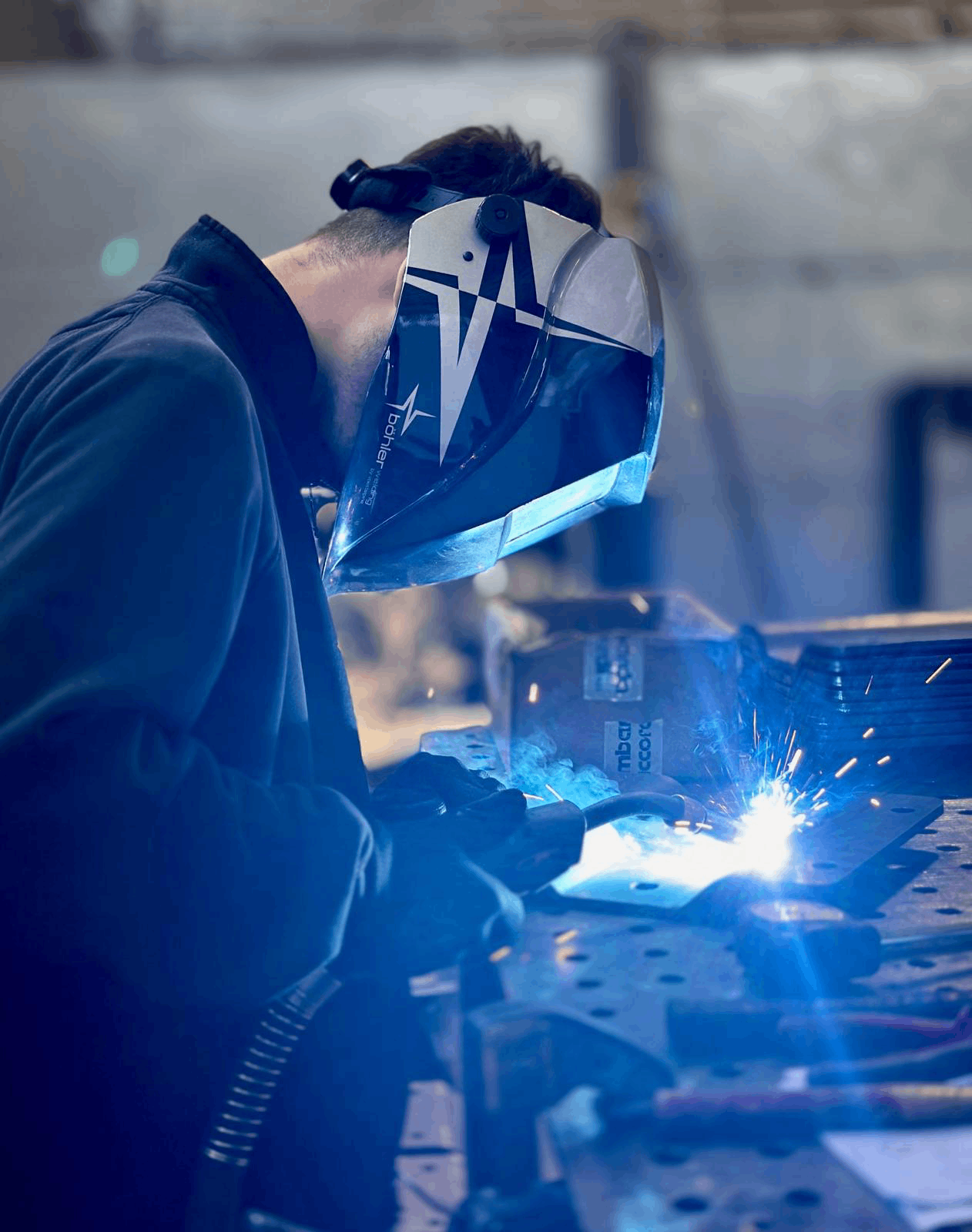 Saldatore al lavoro con maschera protettiva e saldatura ad arco